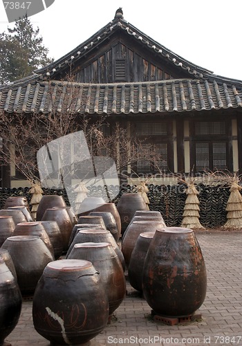 Image of Kimchi pots in front of a traditional Korean house