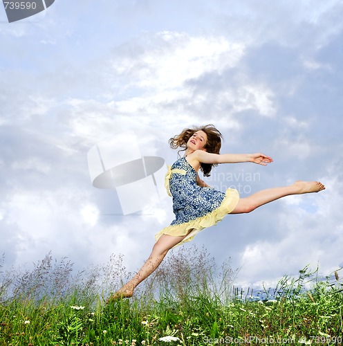 Image of Young girl jumping in meadow