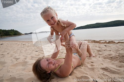 Image of Mum with daughter play on beach