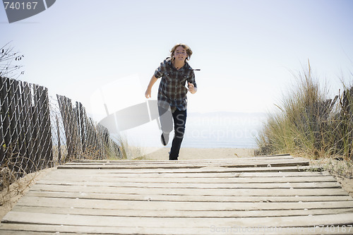 Image of Boy Running On Beach Walkway