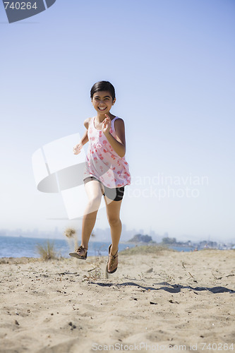 Image of Smiling Girl Running on Beach