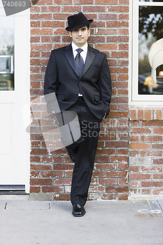 Image of Man in Suit and Tie Leaning against Wall