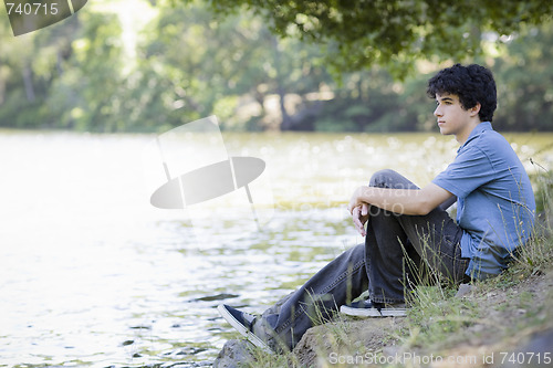 Image of Teen Boy Sitting By Lake