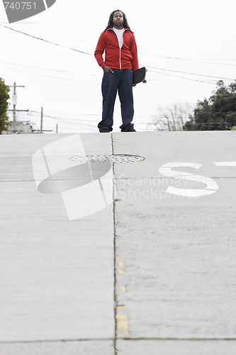 Image of Teen Boy Standing with Skateboard