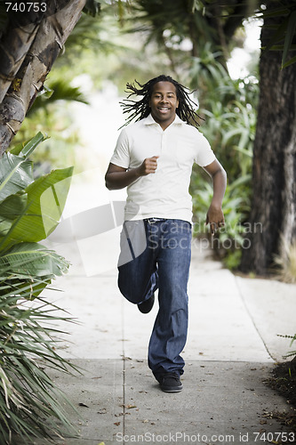 Image of Teenage Boy Running on Sidewalk