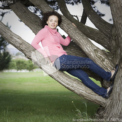 Image of Young Woman Sitting in Tree