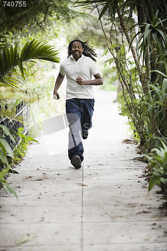 Image of Teenage Boy Running on Sidewalk