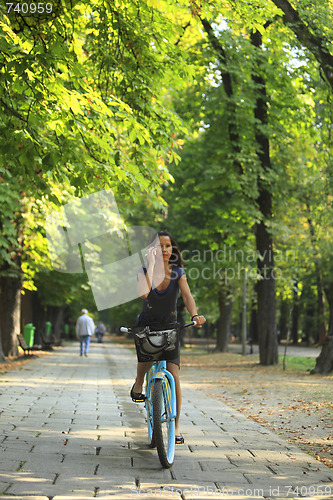 Image of Woman on the phone riding bicycle