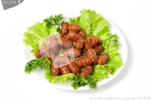 Image of grilled sausages on green lettuce