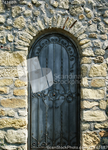 Image of old iron door in the ancient stone wall