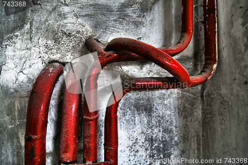 Image of Red bent pipes on concrete walls