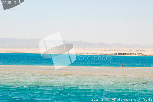 Image of Lonely man walking on sand beach