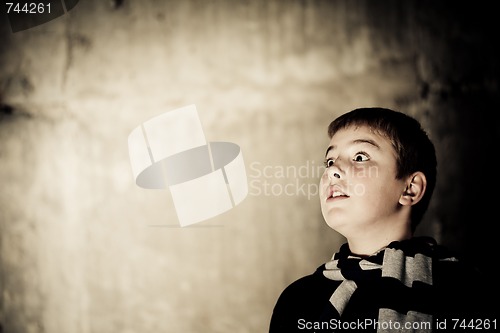 Image of Young boy looking up with hope in his eyes copy space high contrast flattened colours