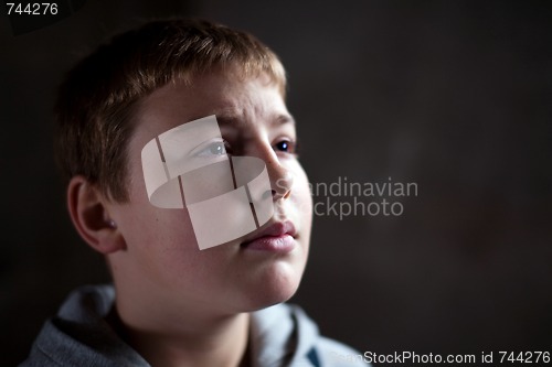 Image of Young boy looking up with hope and despair in his eyes 