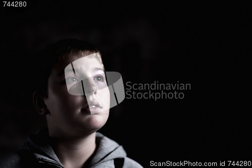 Image of Young boy looking up with hope in his eyes Low key high contrast copy space