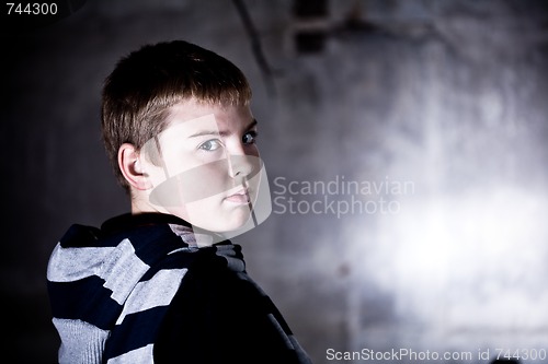 Image of Boy looking over the shoulder against grunge background lit with flash High contrast