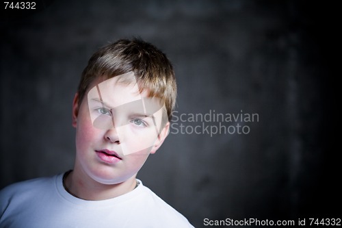 Image of Handsome teenaiger looking self assured at camera portrait underexposed 