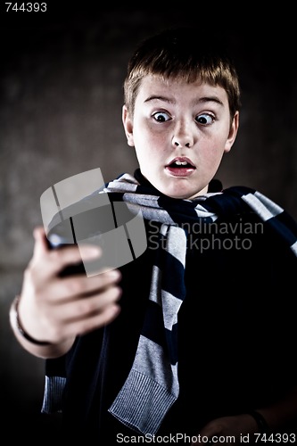 Image of scarry teenaiger looking at his mobile phone - you've got the message! High contrast