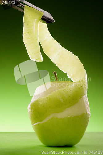 Image of peeled green apple and peeler