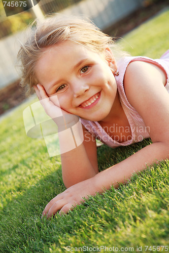 Image of Happy girl relaxing on a grass