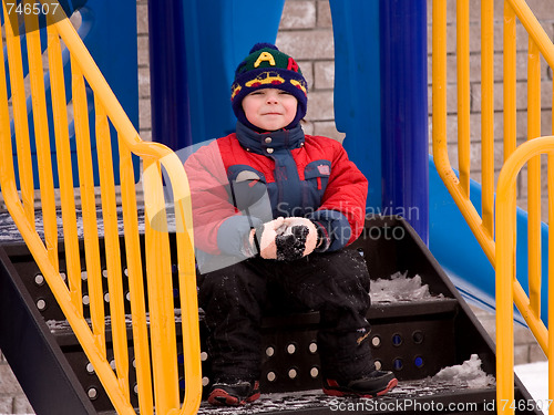 Image of The little boy in the street in the winter