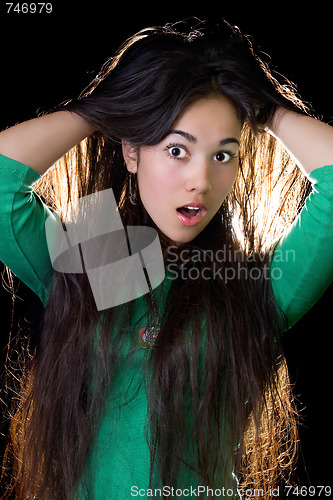 Image of Portrait of the surprised girl. Isolated on black