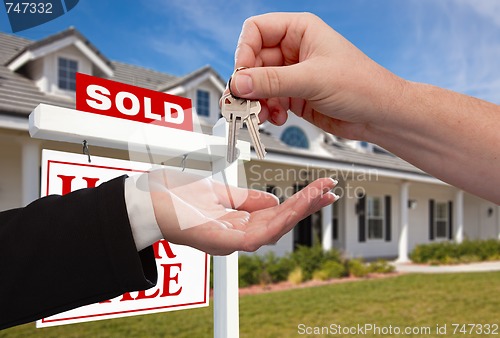 Image of Handing Over the House Keys in Front of Sold New Home