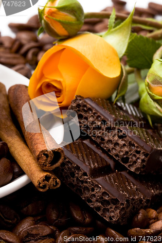 Image of chocolate, coffee, cinnamon sticks and yellow flower