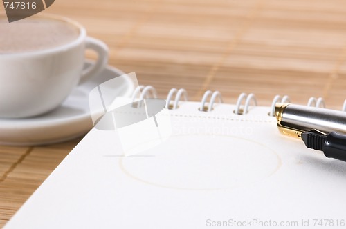 Image of pen, notebook and cup of coffee