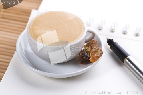 Image of pen, notebook and cup of coffee