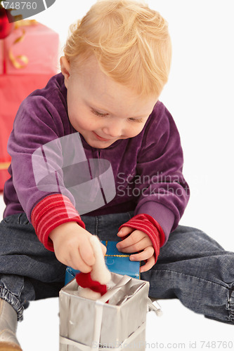 Image of Cute Little girl playing with christmas presents