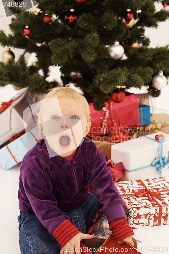 Image of Christmas - Surprised child opening gifts