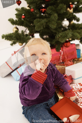 Image of Shhh - Cute baby sneakily opening christmas gifts