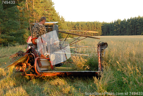Image of man operates an old tractor