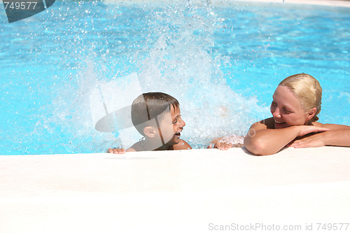 Image of son and mom swim and play in the pool