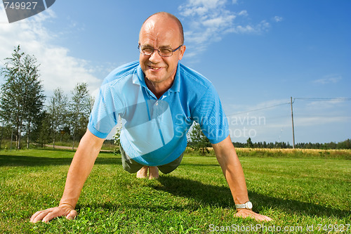 Image of Older man doing push-ups