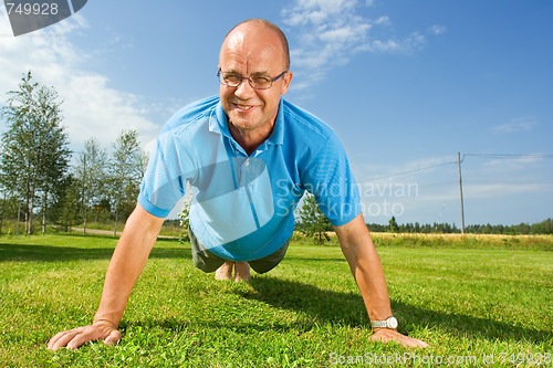 Image of Middle-aged man doing push-ups