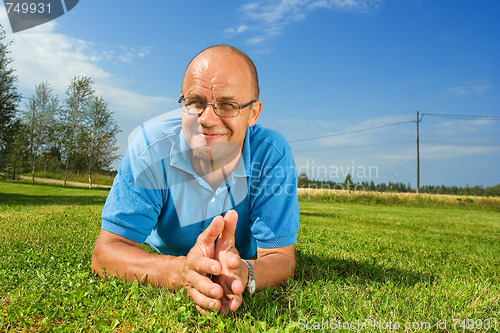 Image of Middle-aged man smiling on a grass