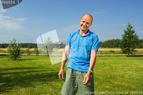 Image of Middle-aged man smiling on a grass   