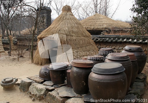 Image of Kimchi (pickled cabbage) pots outside at straw tent