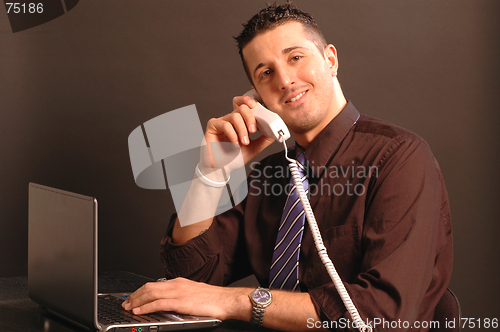 Image of man on phone while on computer 2431