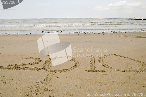 Image of 2010 written in the sand.