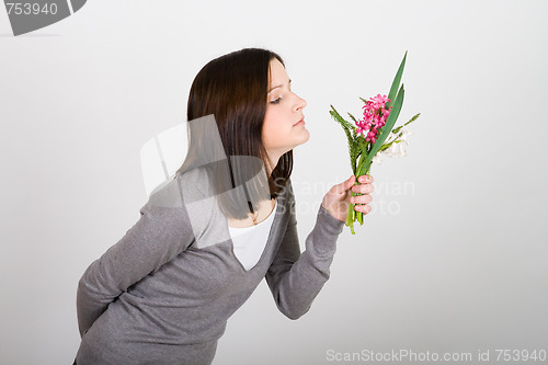 Image of Woman standing and holding  bouquet 