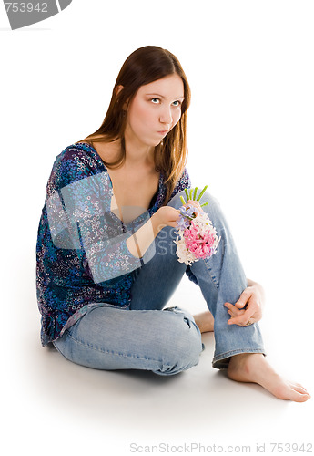 Image of Woman depressed siting on the flor with flowers in hand