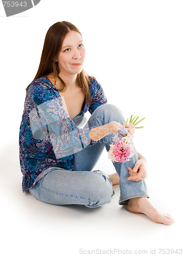 Image of Confused woman siting on the flor with flowers in hand