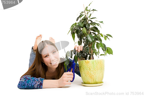 Image of Woman laying on the floor cutting plant