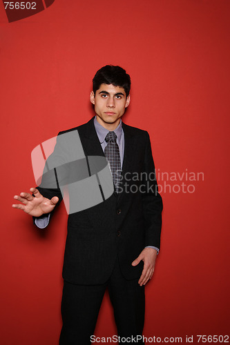 Image of Young man in suit over red wall