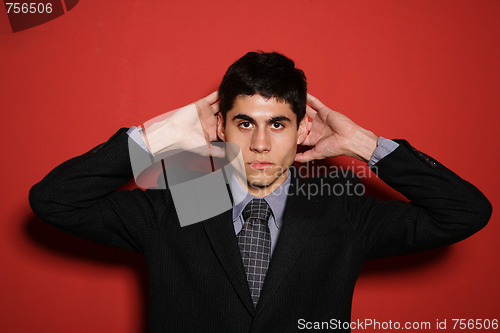 Image of Young man in suit over red wall