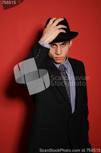 Image of Young man in suit over red wall