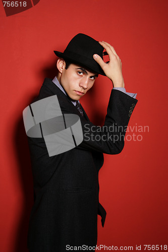 Image of Young man in suit over red wall